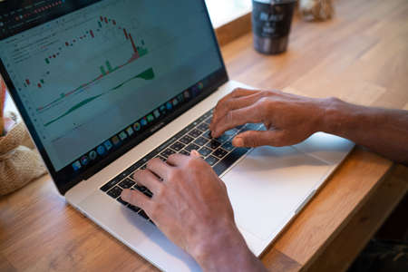 Business man hand use laptop computer with coffee drink sitting in cafe close up business man handの写真素材