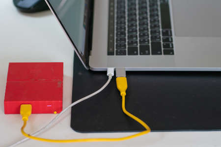 External hard drive connect to laptop computer working on table storage conceptの写真素材