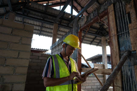Foreman inspecture new house building holding tablet computeer for record data in construction siteの写真素材