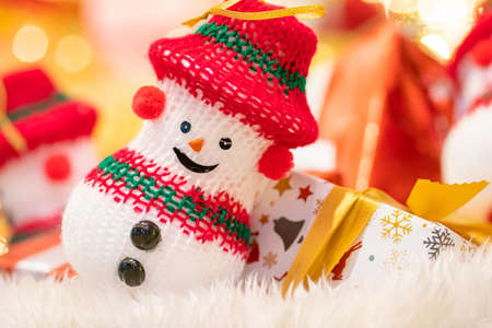 Happy smiling snow doll with gift box on christmas decoration background with bokeh night sceneの写真素材