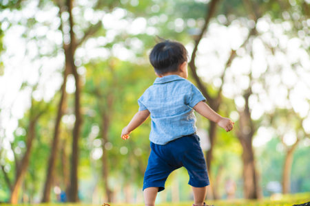 Toddler boy playing freedom walk in city park boy with outdoor activityの写真素材