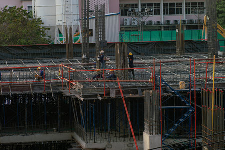 Construction engineer team and mechanical working with crane and building under construction