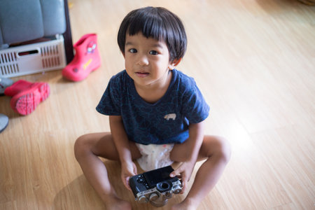 Little asian boy hold camera learn to take photo happy boy with cameraの写真素材