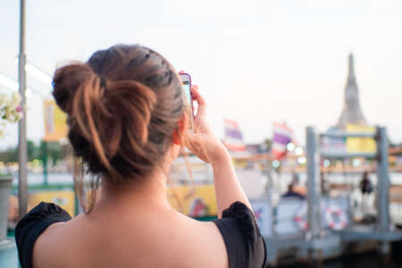 Beautiful asian women travel in bangkok take photo with sightseeing place temple and city vacation conceptの写真素材