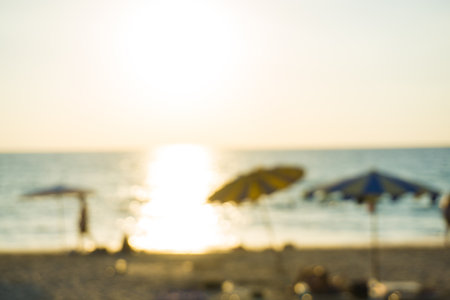 Abstract blurred people recreation on sea beach sunset summer vacation backgroundの写真素材