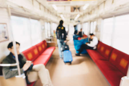Blurred image of people traveling by train with luggage on seat.の写真素材