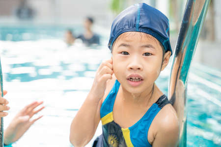 Little asian kindergarten girl practice swim in swimming pool outdoor sportの写真素材