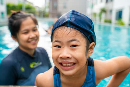 Little asian kindergarten girl practice swim in swimming pool outdoor sportの写真素材