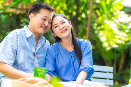 Happy asian senior couple taking with coffee drink in green garden happy morningの写真素材