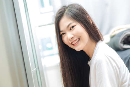 Beautiful smiling asian women relaxing in cozy room asian womenの写真素材