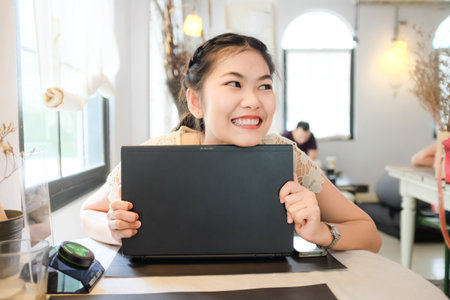 Women use laptop sitting coffee with ambient light business womenの写真素材