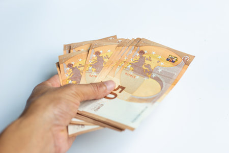 Men hand hold 50 euro bundle money on white background