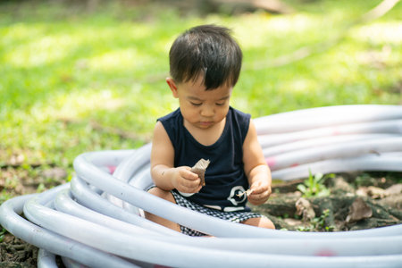 Toddler asian 2 year boy playing on green grass in nature park outdoor activityの写真素材