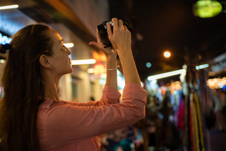 Traveller backpack woman take photo in Yaowarat street at night traditional asia city in Bangkok Thailandの写真素材