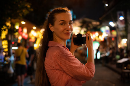 Traveller backpack woman take photo in Yaowarat street at night traditional asia city in Bangkok Thailandの写真素材