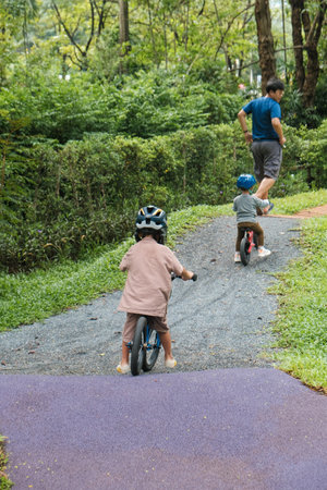 Portrait little cute adorable asian kindergarten boy in safety helmet enjoy having fun riding...