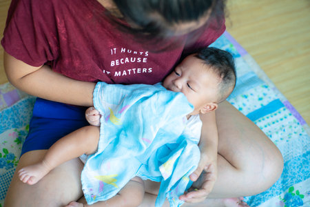 Mom hand sucking snot from baby nose healthy concept