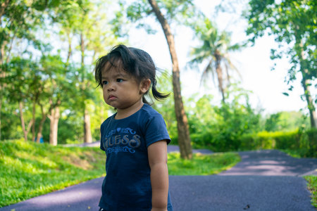Portrait of happy asian toddler girl walking in city public tree park outdoor activity