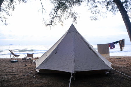 Family camping tent on beach front with pine tree forest summer vacation nature background