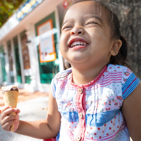 Happy asian preschool girl enjoying eat icecream travel in summer city sweet food