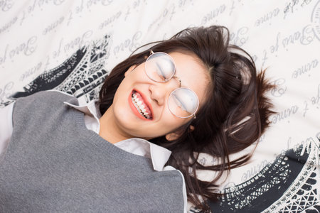 Glasses women relax lying on bed white blanket