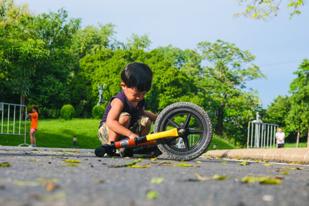 Preschool asian boy practice riding balansc bike in city park outdoor activityの写真素材