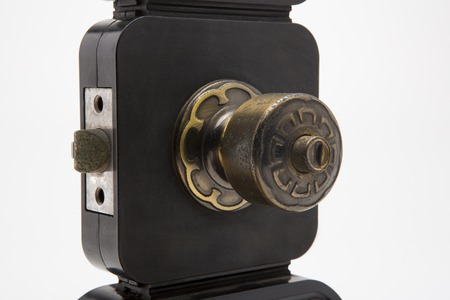 Aluminium door knob on the black door white background.