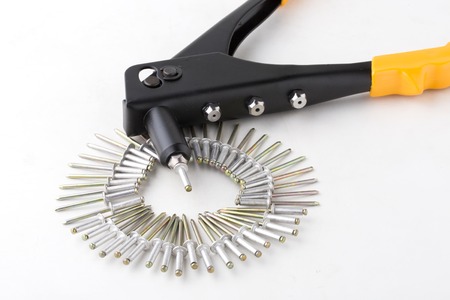 black rivet pliers and rivet on white backgroundの写真素材