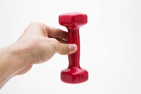Red rubber coated dumbbell in hand isolated on white background.の写真素材
