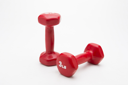 Red rubber coated dumbbell in hand isolated on white background.の写真素材