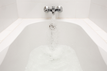 Luxury bath tub and faucet with water.の写真素材