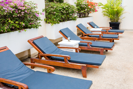 poolside deckchairs with blue swimming pool