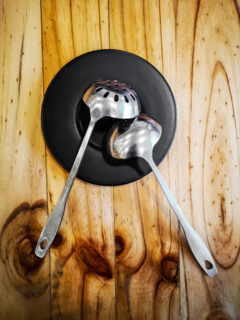 Metal Scoop in Plate on Wooden Table