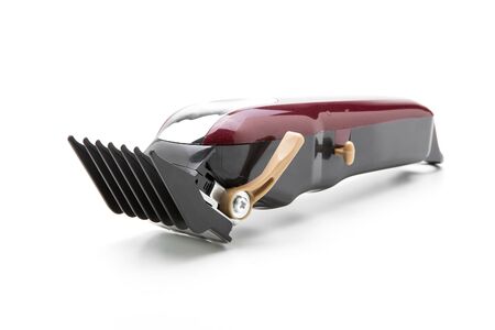 Red clippers for cutting hair on a white background