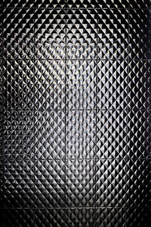 Shiny black tiles in the bathroom as a background.;