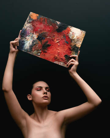 Red and black body paint. Woman with body art. Young girl with bodypaint. An amazing model with makeup.の写真素材