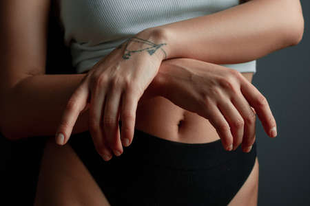 Beautiful female hands, perfect white skin, tattoos on black backgroundの写真素材