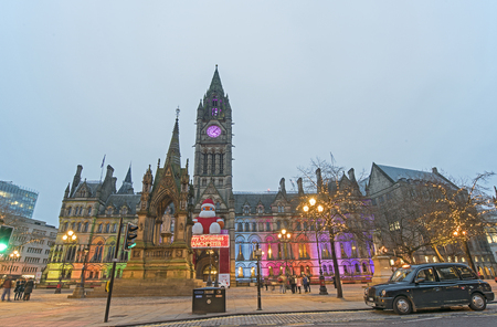 A black colour taxi was parking in front of the Manchester Town Hall and Clock Tower during Christmas Holiday, Manchester - December 2015のeditorial素材