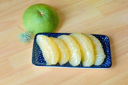 pomelo slices in a blue plate,wooden backgroundの写真素材