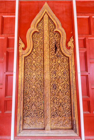 This antique door is located at Wat Yai Suwannaram in Petchburi, Thailand. The damage on the upper right hand of the door was axed by burmese soldier in an attempt to get to the people hiding inside.の写真素材