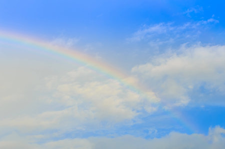 Rainbow and sun ray over the cloud and blue sky right afte the rainの写真素材
