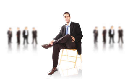 business leader in his chair posing with his teamの写真素材