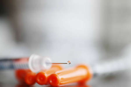 a water drop is at the very end of a syringeの写真素材