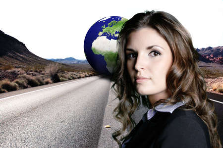 businesswoman is posing in front of a long stretch of road with mountain in the background with earth in the middle の写真素材