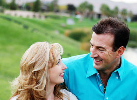 a happy couple smiling in green park enivironmentの写真素材