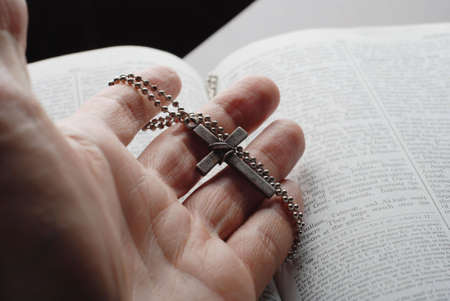 holy bible open with a cross on a handの写真素材