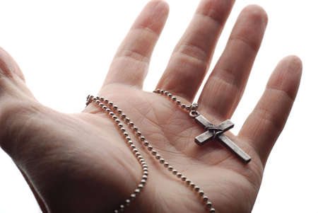 a hand is holding the cross in its palmの写真素材