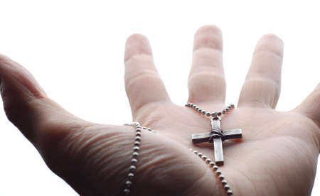 a hand is holding the cross in its palmの写真素材