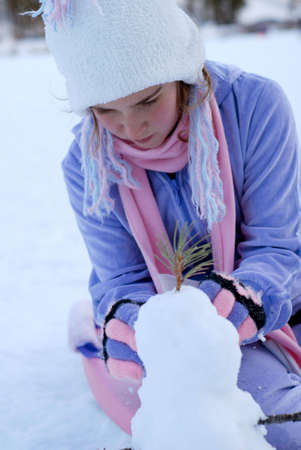 young girl is playing in the snowの写真素材