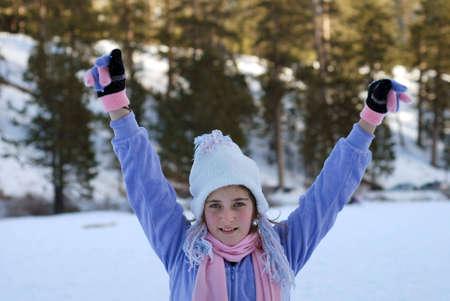 young girl is playing in the snowの写真素材
